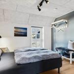 Schlafzimmer mit Bett, Wandbild und Fenster zur Außenseite.
