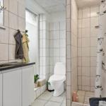 Badezimmer mit Waschbecken, Toilette und Dusche mit Vorhang.