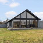 Moderne Villa mit großem Glasbereich und Terrasse im Freien.