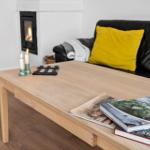 Ein Wohnzimmer mit einem Sofa, einem Kamin und einem Holztisch mit Büchern.