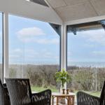 Terrasse mit Sitzgelegenheiten und Blick auf die Küste