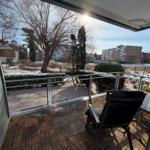 Terrasse mit Sitzgelegenheit und Blick auf schneebedeckten Garten und Wohnhäuser.
