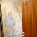 Tür mit Nummer 15 und Seekarte an der Wand