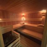 Sauna mit Holzbanken und Heizung im Innenraum.