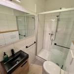 Badezimmer mit Dusche, Toilette und Waschbecken.