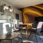 Küche mit Essbereich und Wandbild. Tisch mit Stühlen und TV.