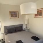 Schlafzimmer mit Bett, Nachttischen und Decken.