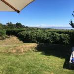 Garten mit Liegestühlen und Blick aufs Wasser