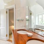 Badezimmer mit Holzwaschtisch, Spiegel und Dusche