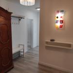 Eingangsbereich mit Holzschrank, Wandlampe und Kleiderständer