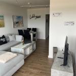 Wohn- und Essbereich mit Sofa, Tisch und Fernseher.