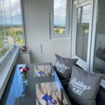 Terrasse mit Sitzgruppe, Tisch und Blick auf Landschaft.