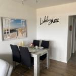 Esszimmer mit Tisch, Stühlen und Wandbild. Wanddekoration: Lieblingsplatz.