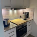 Küche mit Dunstabzug, Herd und Arbeitsfläche