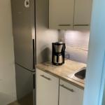 Küche mit Kühlschrank, Arbeitsplatte und Spüle.