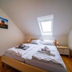 Doppelbett mit Fenster, Nachttische und Wandbild.