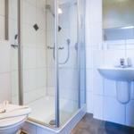 Badezimmer mit Dusche, Waschbecken und Toilette.