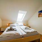 Schlafzimmer mit Doppelbett, Dachfenster und Wandbild