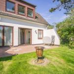 Wohnhaus mit Terrasse, Grill und Garten. Satellitenschüssel und Bäume sichtbar.