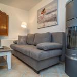 Wohnzimmer mit Sofa, Kamin und Fernseher.