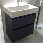 Waschbecken mit Spiegelschrank und Duschbereich