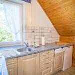 Küche mit Spüle, Fenster und Holzdecke