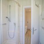 Duschkabine mit Handbrause und Heizkörper an der Wand