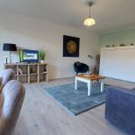Wohnzimmer mit Sofa, Couchtisch und Fernseher an der Wand.