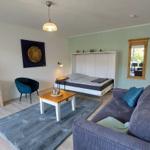 Wohnzimmer mit Sofa, Bett und Fernseher.