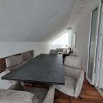 Esszimmer mit großer Tisch und Stühlen, Sicht auf Wohnbereich und Schlafzimmer.