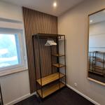 Schlafzimmer mit Kleiderschrank, Spiegel und Fenster