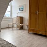 Zimmer mit Holzmöbeln, Fenster und Teppichboden