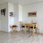 Essbereich mit Tisch, zwei Stühlen und Wanddekoration.