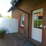 Rotes Backsteinhaus mit weißer Tür und Pflanze im Vorgarten.