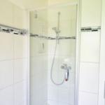 Dusche mit Glaswand und Duschbrause