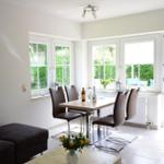 Wohn- und Essbereich mit Tisch, Stühlen und Blick auf Garten.