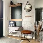 Eingangsbereich mit Schuhschrank, Spiegel und Sitzgelegenheit.