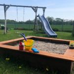Unsere Sandkiste mit Rutsche und Schaukel