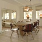 Esszimmer mit Holztisch und Stühlen, Sicht auf Wohnzimmer mit Sofa und Kamin.