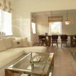 Wohn- und Essbereich mit Sofa, Tisch und Kamin.