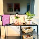 TV-Tisch mit Blumen, Pflanze und Gastinformation