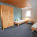 Zimmer mit zwei Betten, Schrank und Bad mit Waschbecken