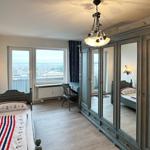 Schlafzimmer mit Blick aufs Meer, großes Spiegelschrank und Schreibtisch.