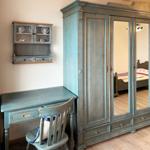 Schreibtisch und Kleiderschrank mit Spiegeltüren in einem Schlafzimmer.
