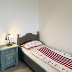 Ein Schlafzimmer mit einem Bett, Nachttisch und einer Lampe.