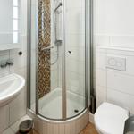 Badezimmer mit Dusche, Toilette und Waschbecken.