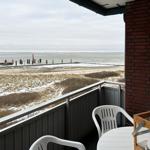Terrasse mit Blick auf schneebedeckten Strand und Hafen.
