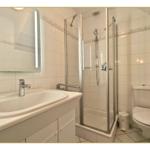 Badezimmer mit Dusche, Waschbecken und Toilette.