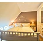 Schlafzimmer mit Dachschrägen, Bett, Nachttischen und Kleiderschrank.