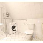 Badezimmer mit Dusche, Waschmaschine und Toilette. Holzschrank mit Nautikmotiven.